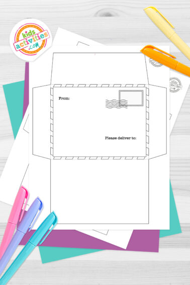 Black and white printable envelope template with a Christmas theme on top of blue-green and purple sheets with assorted crayons on a dark grey background. printed pdf version from Kids activities blog.